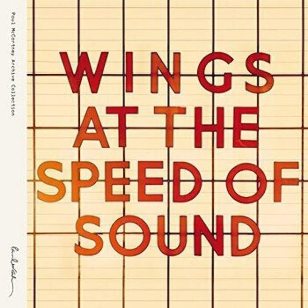 Book cover for 'Wings at the Speed of Sound' by Paul McCartney, featuring large red and orange gradient block letters on a beige lined notebook paper background.