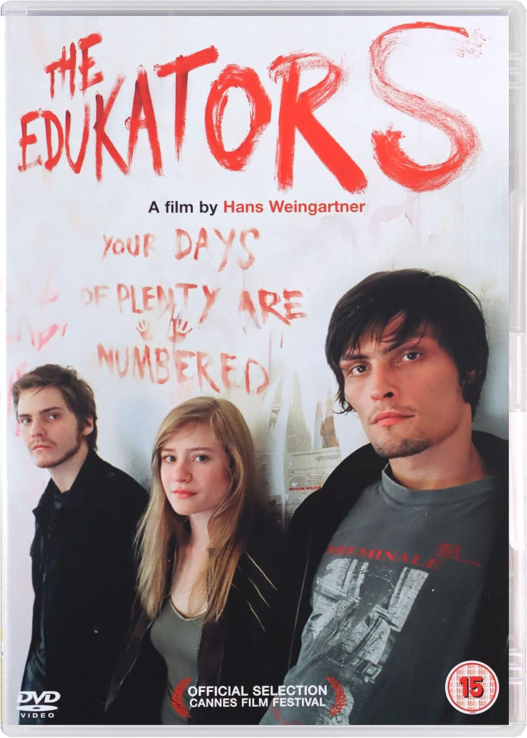 DVD cover for the film 'The Educators' starring Hans Weingartner, featuring three young men against a white background with red graffiti-style text. Includes a DVD logo, Cannes Film Festival selection badge, and a 15 rating mark.