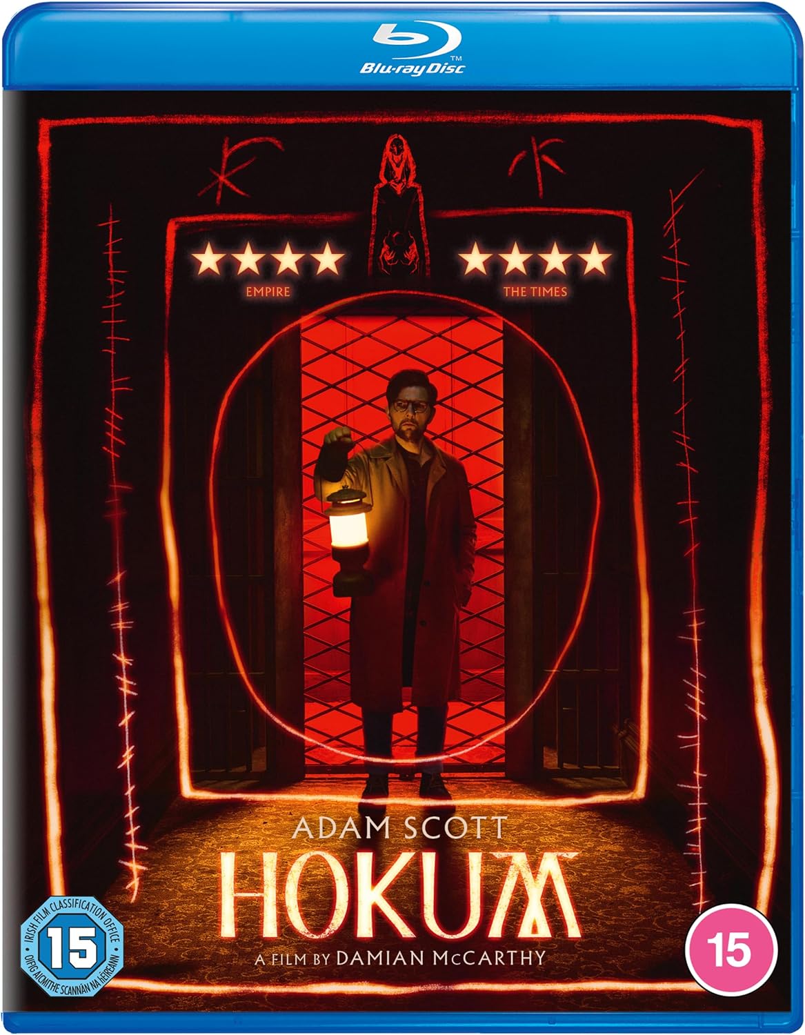 Blu-ray cover for the film 'Hokum' starring Adam Scott, featuring a dark red and black design with glowing orange-red neon-style borders, a lantern-lit figure in the center, and a blue Blu-rayDisc banner at the top.