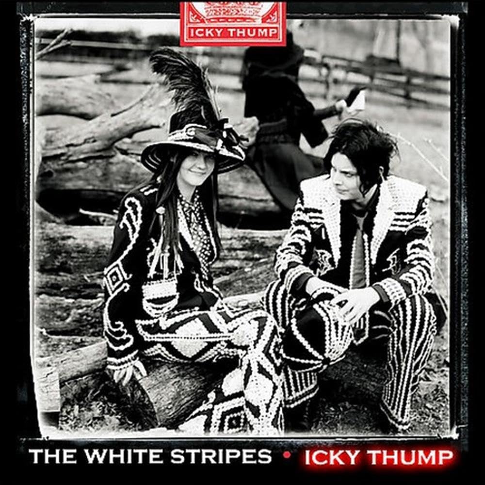 Album cover for 'The White Stripes - Icky Thump', featuring a black-and-white photograph of two people in patterned suits and hats sitting on logs outdoors, with the band name 'ICKY THUMP' in red at the top and the album title 'THE WHITE STRIPES • ICKY THUMP' in red at the bottom.