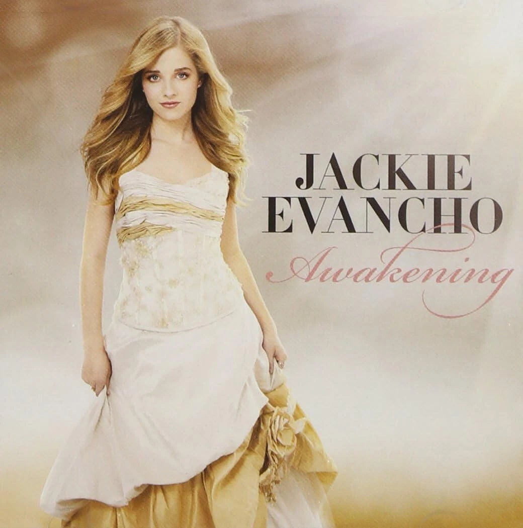 Album cover for 'Awakening' by Jackie Evancho, featuring a portrait of the artist in a white and gold gown against a soft beige background with the album title and artist name printed on the right.