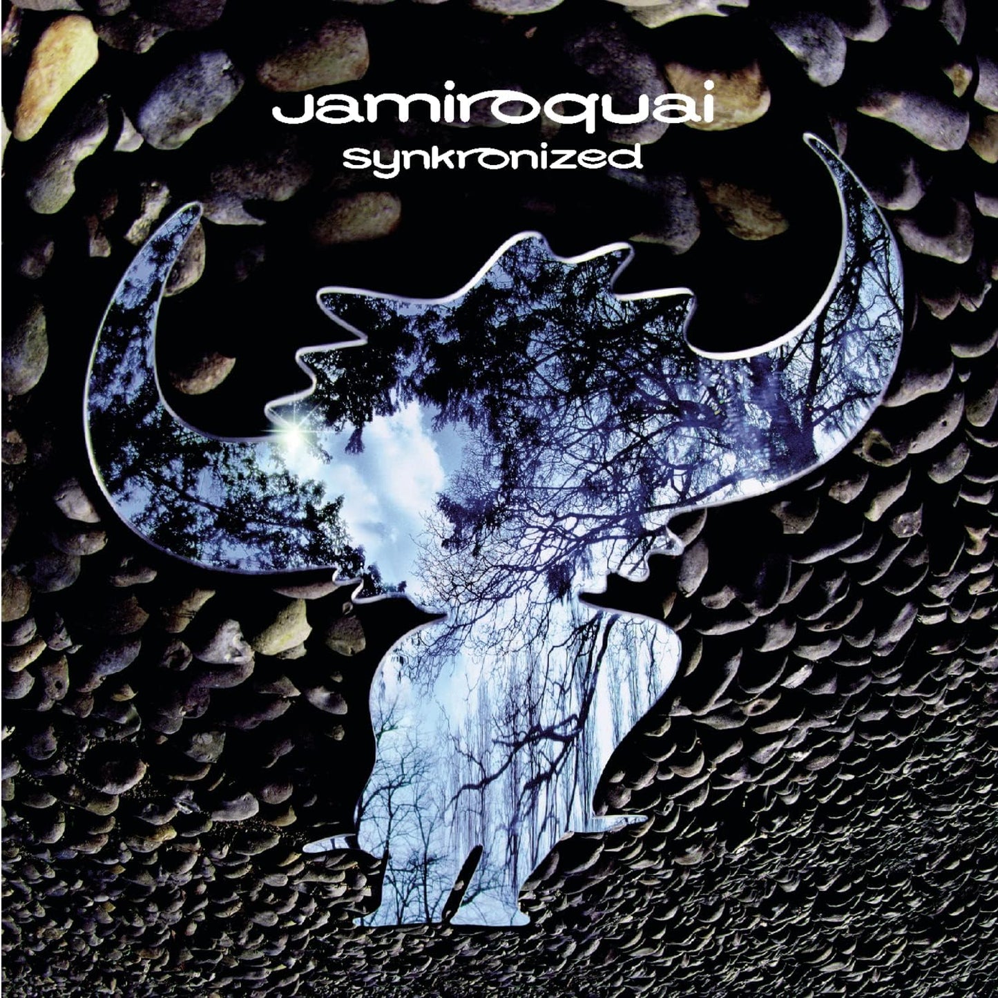 Album cover with 'jamiroquai' and 'synkronized' text, featuring a stylized moon and tree design on a pebble background.