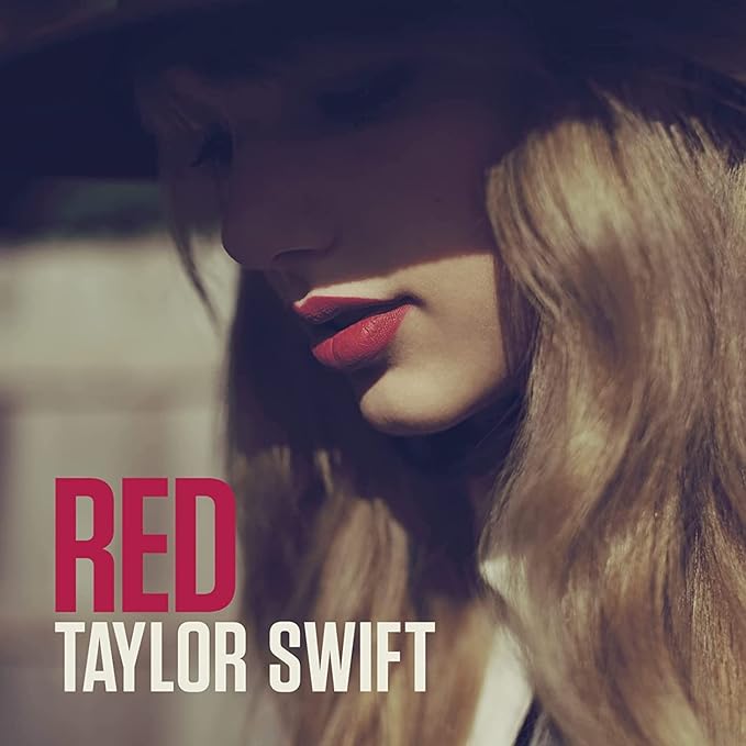 A CD cover featuring the artist name 'Taylor Swift' and the album title 'Red' with a red and white color scheme.
