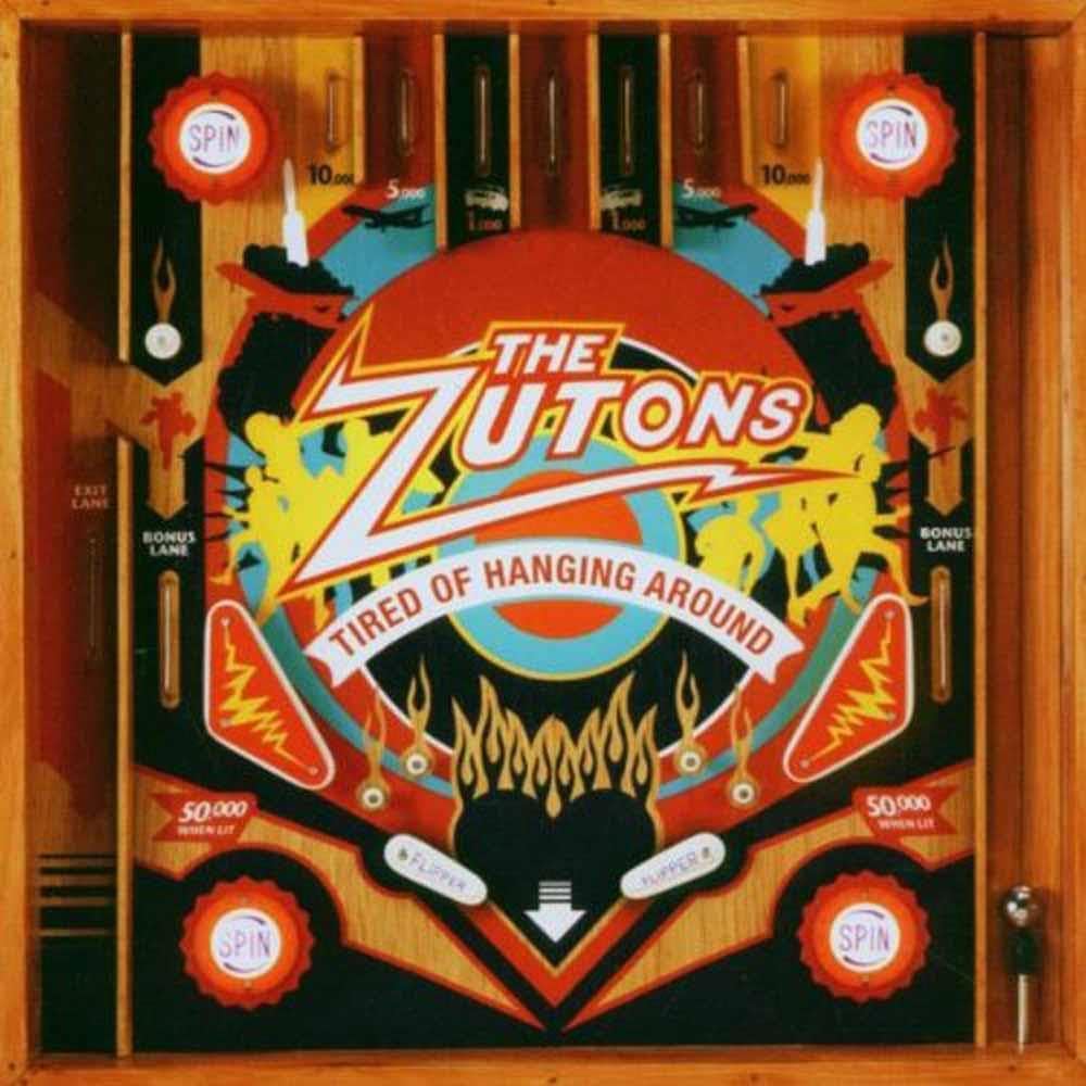 The Zutons - Tired of Hanging Around vinyl record cover art, featuring a detailed illustration of a retro pinball machine with red, yellow, blue, and black graphics on a wooden cabinet frame.