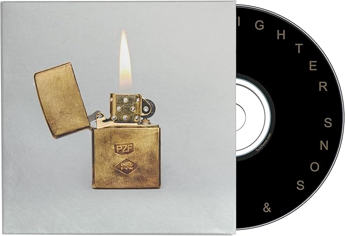 Gold lighter with flame on a gray background, next to a black and white record sleeve.