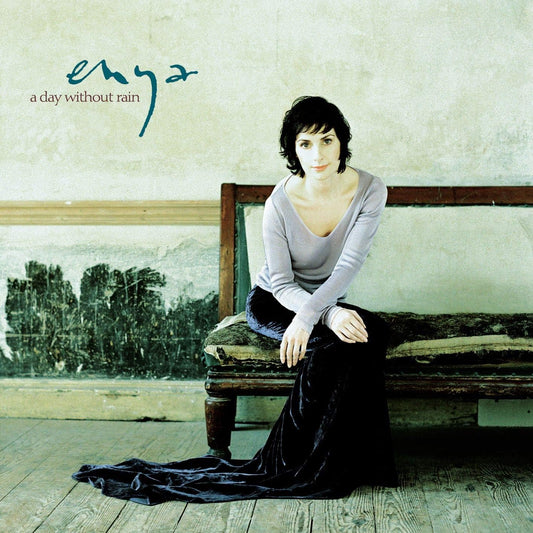 Album cover with a woman sitting on a bench and the title 'Enya: A Day Without Rain' at the top.