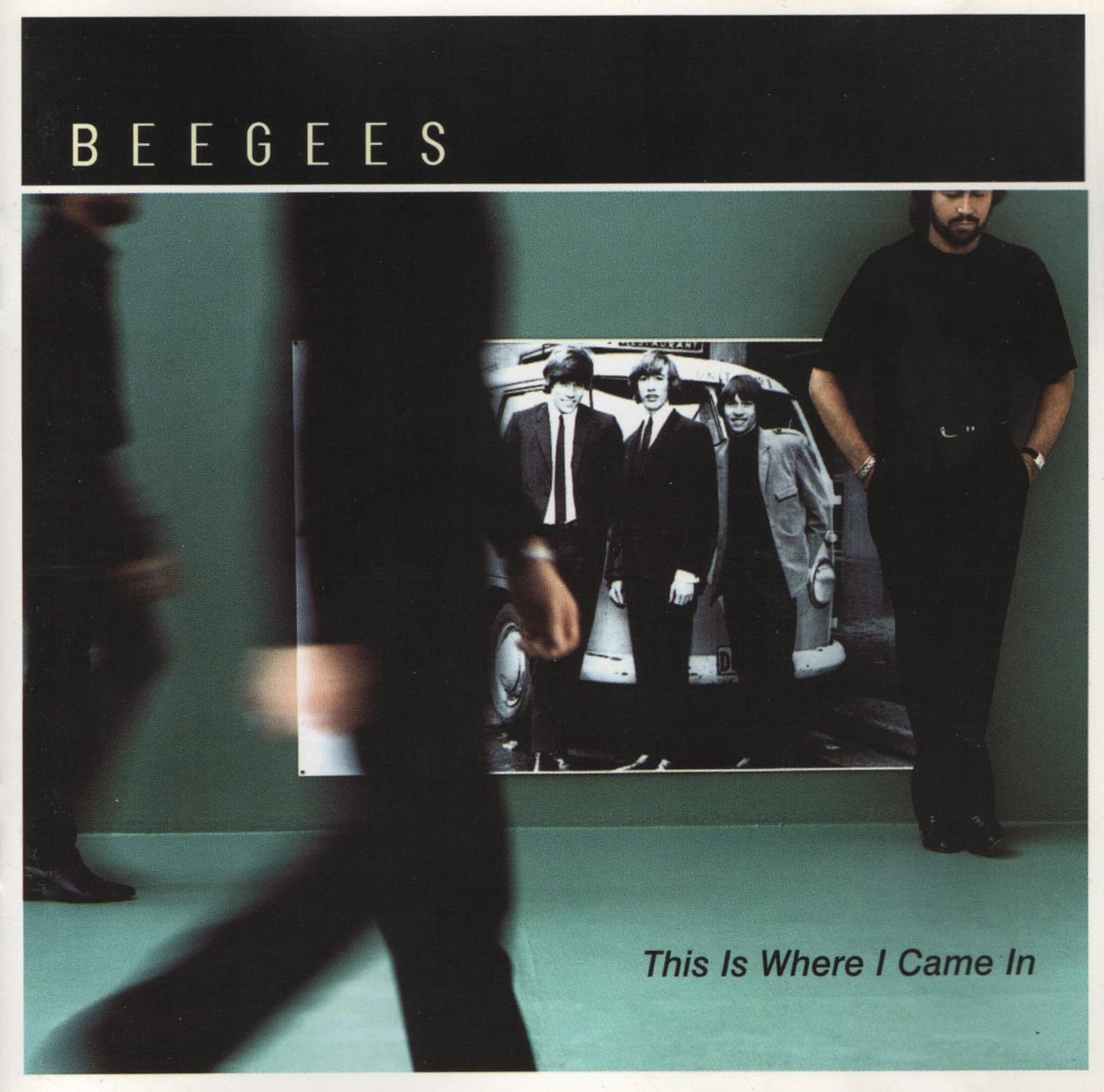 Album cover for 'This Is Where I Came In' by Bee Gees with a person walking past a poster of the band.