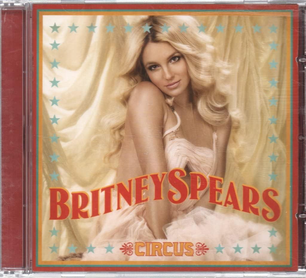 CD cover of Britney Spears' 'Circus' with a woman in a white dress and stars on the background