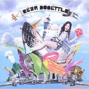 Elza Doolittle album cover artwork featuring a whimsical, surreal collage of elements including a woman in a bikini, a tower, a lion, a cat, flags, and a dice roll against a blue sky background.