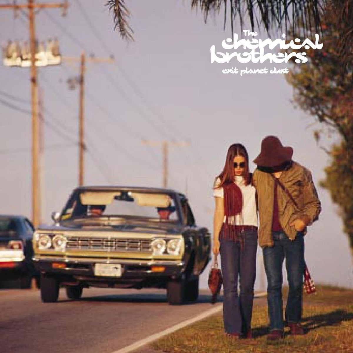 Album cover with two people standing on a road next to a vintage car, featuring 'The Chemical Brothers' and 'Only One Planet'.