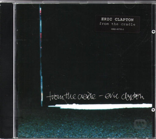 Eric Clapton 'from the cradle' CD album cover in a clear jewel case, featuring a black background with a vertical blue-white line, a white horizontal band, and white handwritten-style text.