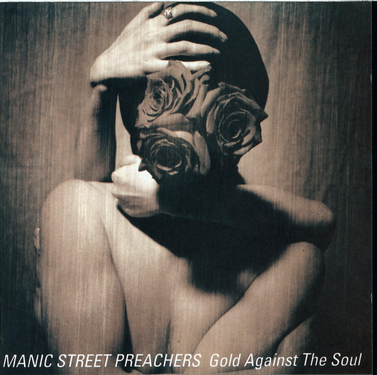 Album cover of 'Gold Against The Soul' by Manic Street Preachers featuring a person wearing a gas mask with roses.