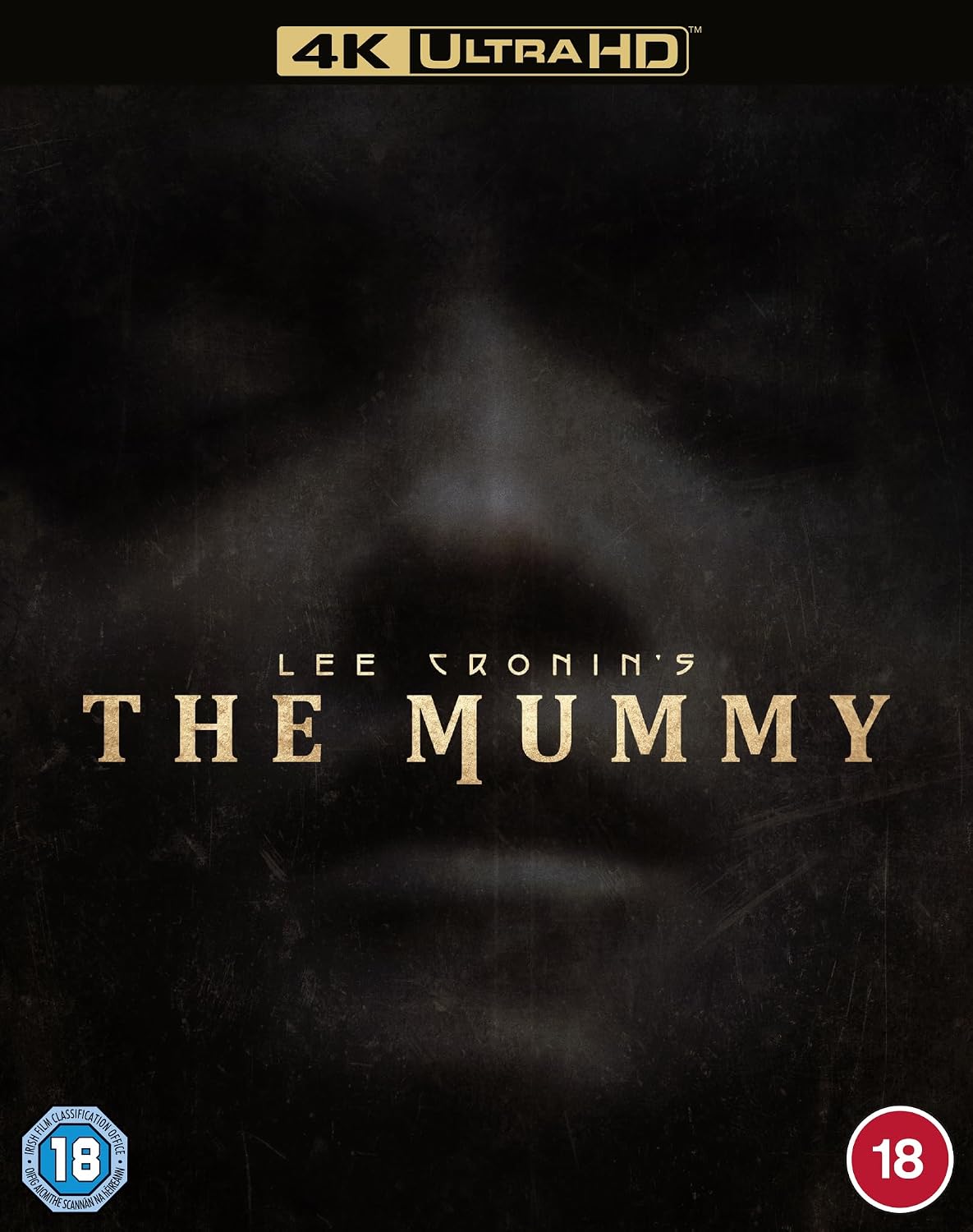 The Mummy 4K Ultra HD movie cover featuring a dark, textured background with a faint mummy face, gold title text, Lee Cronin's name, a 4K Ultra HD banner at the top, and age rating badges in the bottom corners.