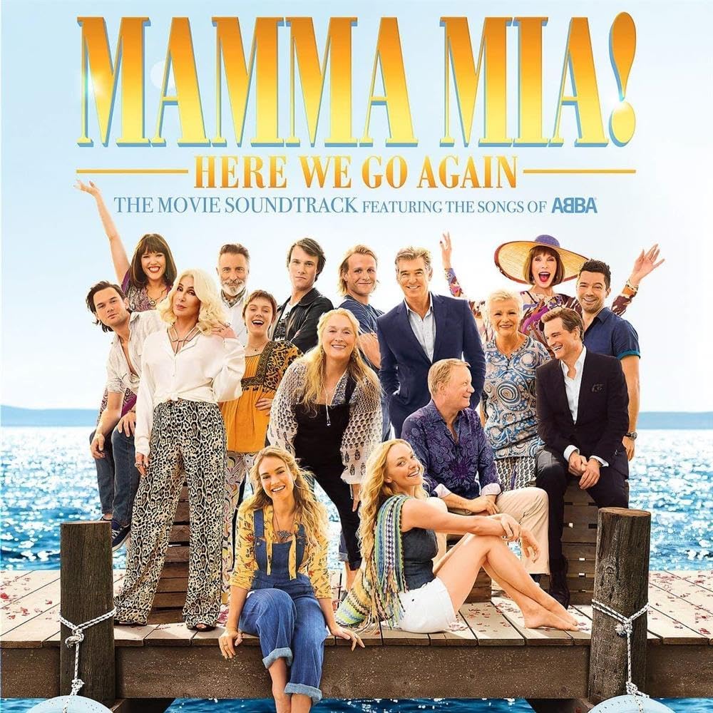 Movie soundtrack cover for 'Mamma Mia! Here We Go Again' with characters on a dock by the ocean.