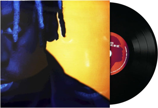 Vinyl record album shown with the sleeve partially covering the record. The cover features a close-up portrait in deep blue tones with a large bright yellow block behind the face.