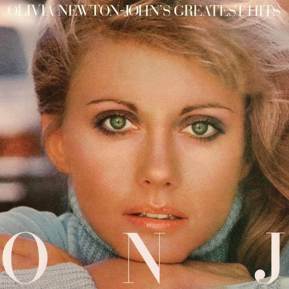 Album cover with a close-up of a person wearing a blue sweater, featuring text 'Olivia Newton-John's Greatest Hits'.
