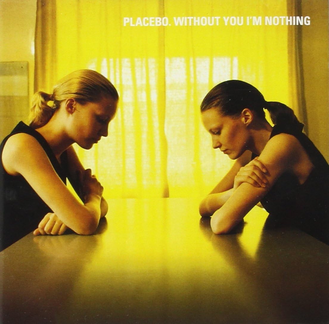 The image on the album cover features two individuals seated at a table, looking directly at each other. Both figures are brunette and dressed in dark clothing, with a yellowish tint to the photograph that gives it a warm, intimate feel.