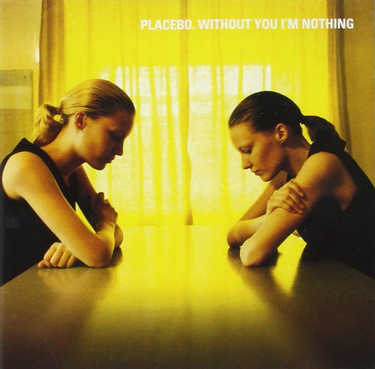The image on the album cover features two individuals seated at a table, looking directly at each other. Both figures are brunette and dressed in dark clothing, with a yellowish tint to the photograph that gives it a warm, intimate feel.