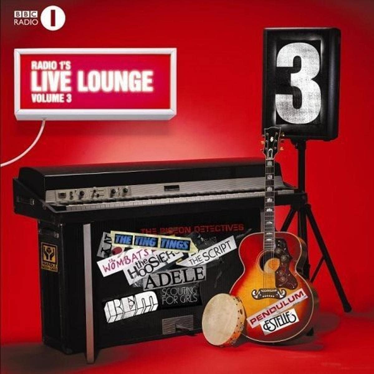 Radio 1s Live Lounge Volume 3 album cover art featuring a black keyboard covered in stickers, a yellow acoustic guitar with 'Pendulum 8888' on it, a small tambourine, and a large speaker displaying the number 3, all set against a solid red background.