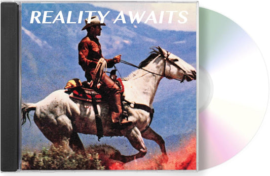 A CD album titled 'REALITY AWAITS' with a western-themed cover showing a cowboy riding a white horse against a mountain background, with part of the silver CD disc visible behind the case.