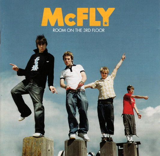 Album cover for 'Room on the 3rd Floor' by McFLY with four band members on wooden planks against a blue sky.