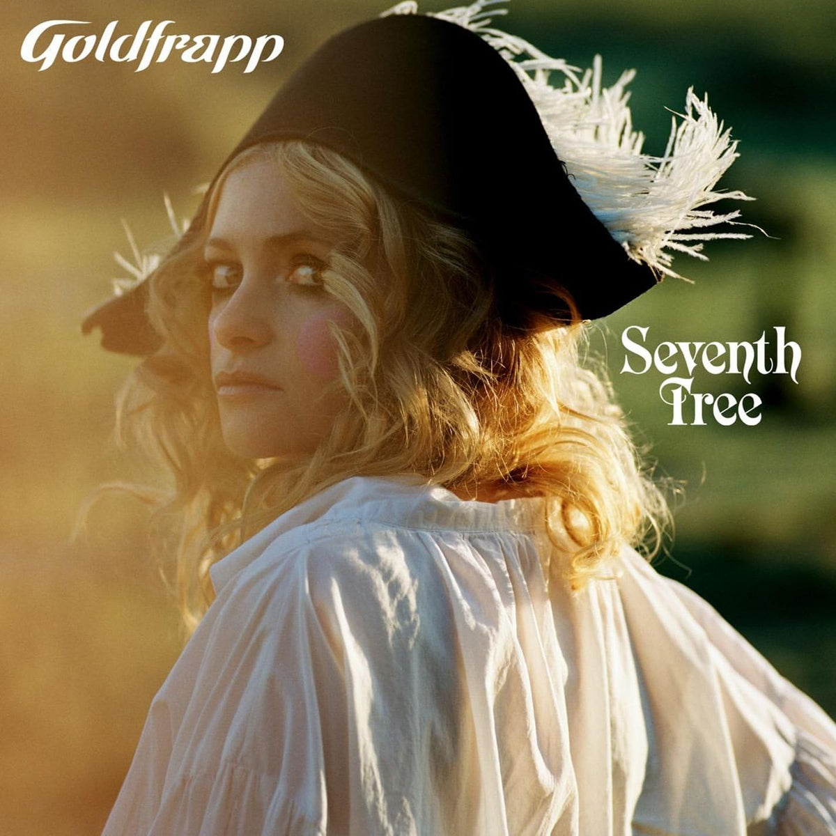 Album cover for 'Seventh Tree' by Goldfrapp featuring a person with a hat and feathered headdress.