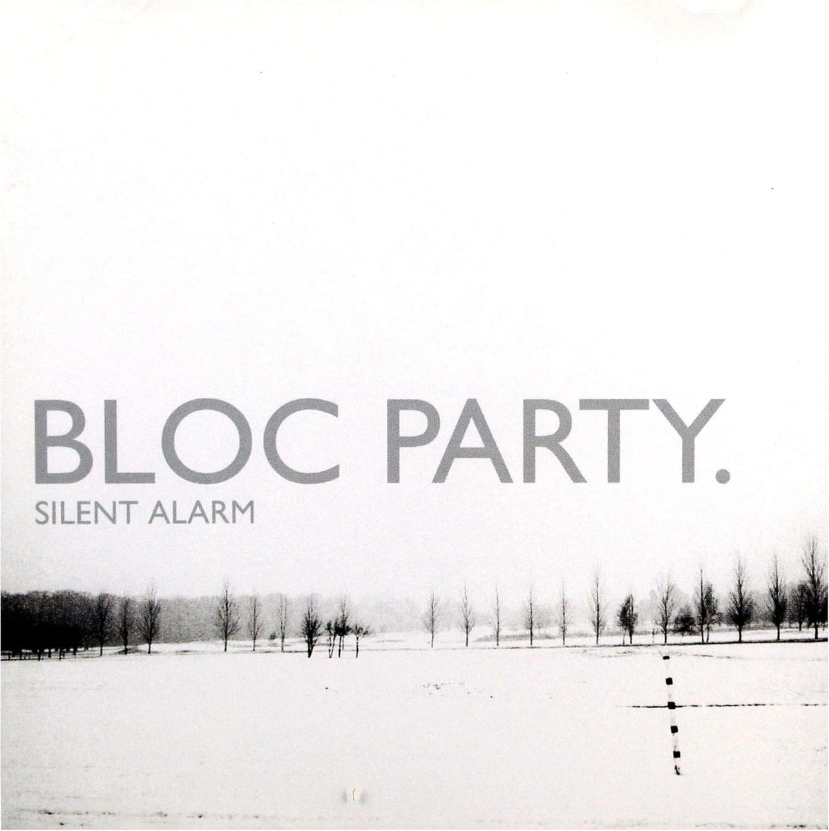 Album cover for 'Silent Alarm' by Bloc Party, featuring a minimalist black and white photograph of a snowy landscape with sparse trees under a pale sky.