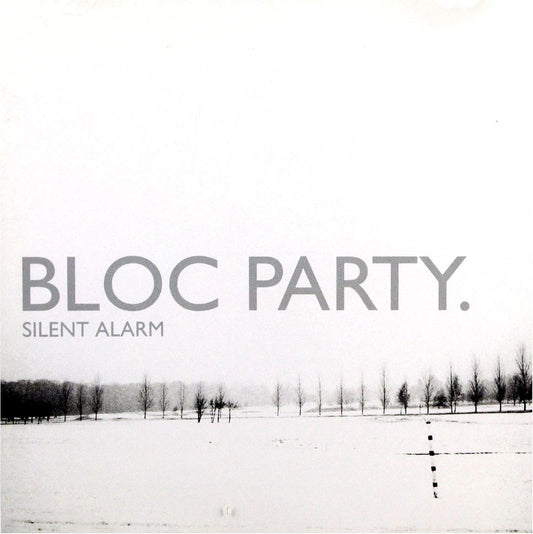 Album cover for 'Silent Alarm' by Bloc Party, featuring a minimalist black and white photograph of a snowy landscape with sparse trees under a pale sky.