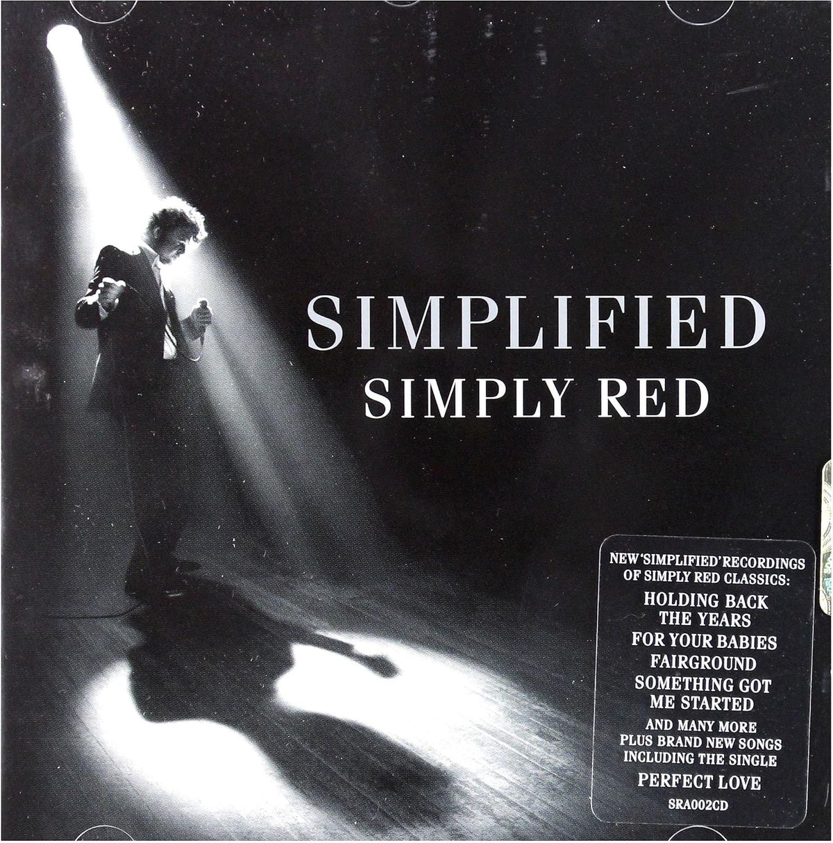 Album cover for Simply Red's 'Simplified' featuring a black-and-white photo of a performer under a spotlight on the left, large white title text reading 'SIMPLIFIED SIMPLY RED' across the center, and a black information box with white text in the lower right corner.