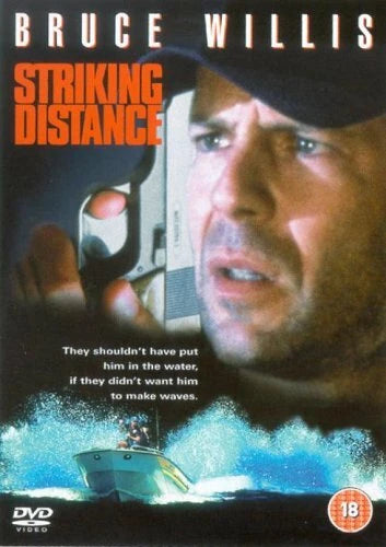 DVD cover for the movie 'Striking Distance' starring Bruce Willis, featuring a close-up of Bruce Willis holding a gun, bold orange title text, and a boat scene at the bottom with an 18 rating logo.