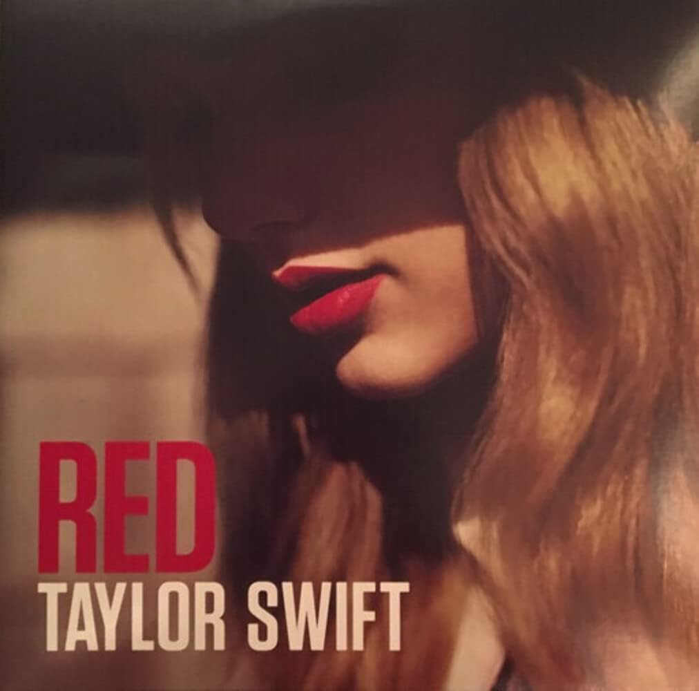 Vinyl record cover featuring Taylor Swift with a red background and the title 'RED' prominently displayed.