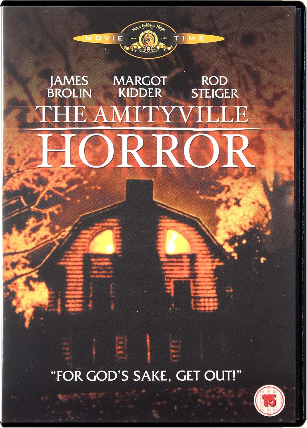 DVD cover for the movie 'The Amityville Horror' featuring a dark haunted house silhouette with glowing windows against a fiery orange background. Visible text includes the movie title, cast names James Brolin, Margot Kidder, and Rod Steiger, a Movie Time banner at the top, and a 15 rating badge at the bottom right.
