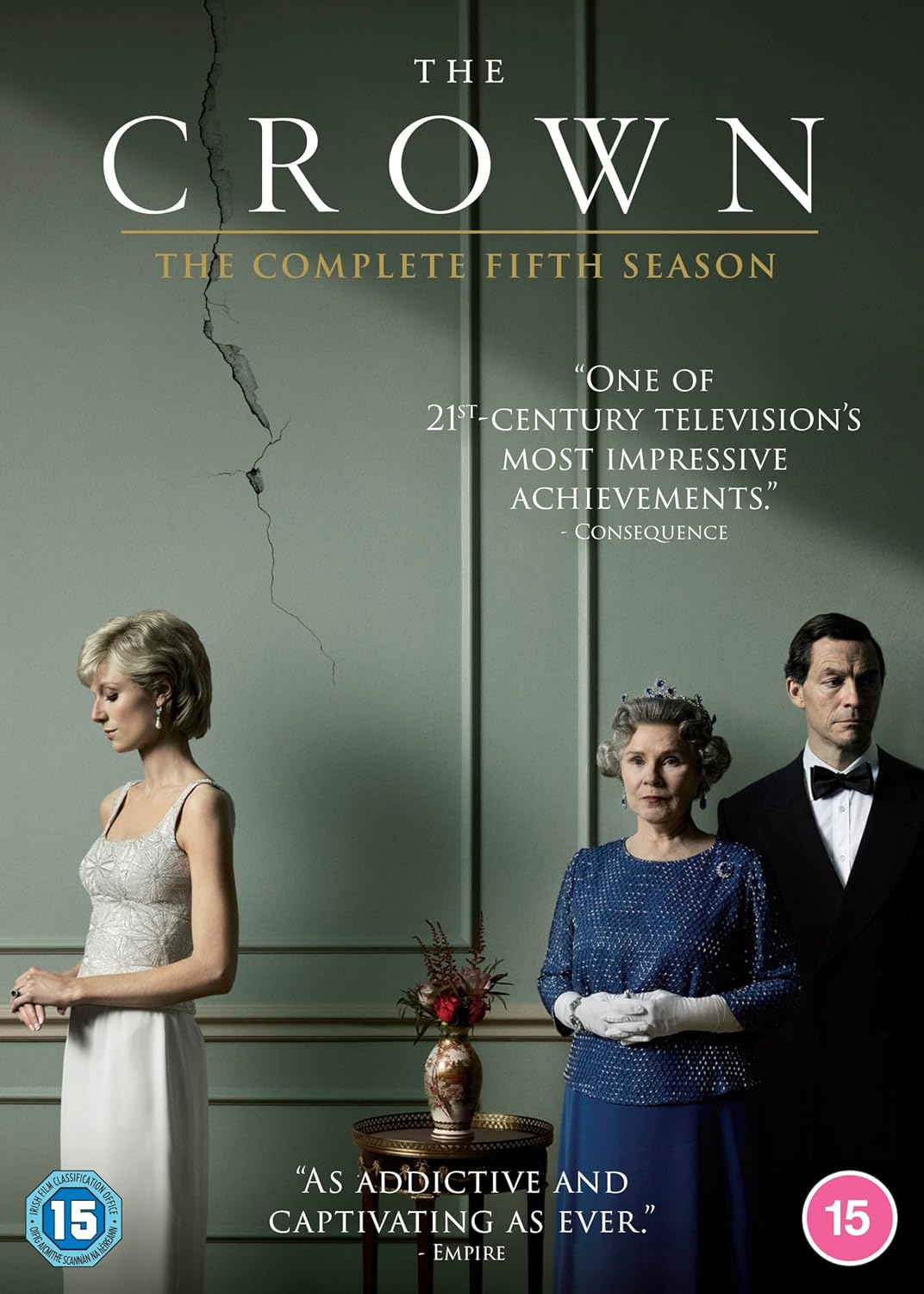 The Crown Season 5 DVD cover featuring Queen Elizabeth in a white gown, Queen Elizabeth II in a blue patterned dress, and Prince Philip in a black tuxedo against a dark green background with the title 'THE CROWN' at the top.