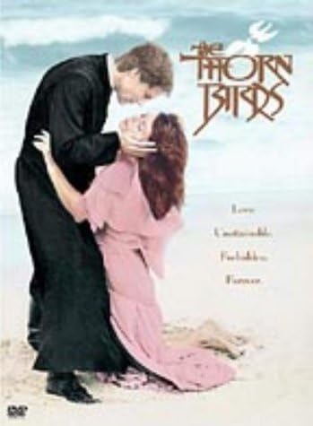 Movie poster for 'The Thorn Birds' featuring a couple embracing on a beach with a dove in the sky.