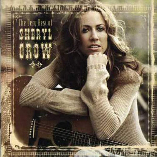 Album cover featuring a woman holding an acoustic guitar with text 'The Very Best of Sheryl Crow' on a decorative background.