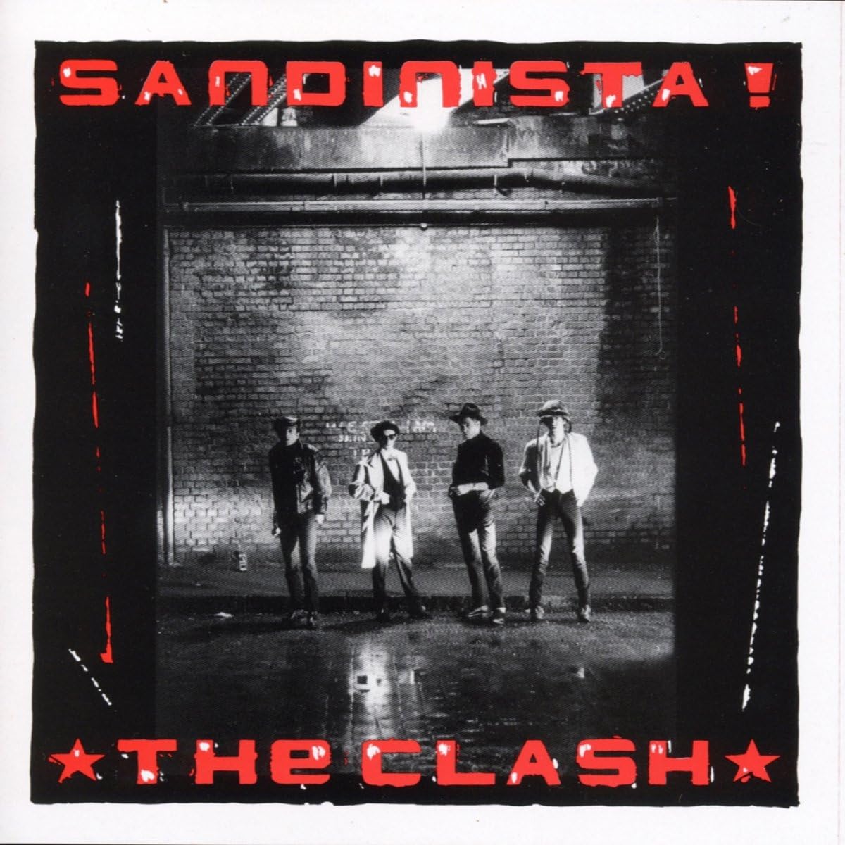 The image features the album cover of "Sandinista!" by The Clash. It displays a black and white photograph of the band members standing in a dimly lit, brick-walled room, with a clear focus on the band's dynamic and edgy presence.