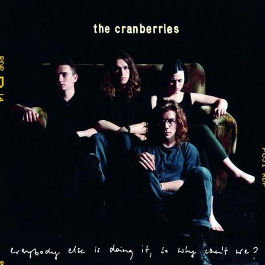 The Cranberries album cover for 'Everybody Else Is Doing It, So Why Can't We?', showing the band members seated in a dark room with the band's name at the top and the album title at the bottom.