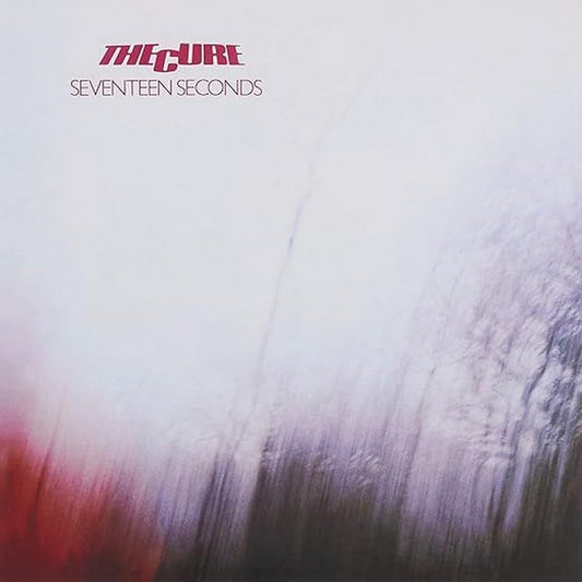 The album cover of 'Seventeen Seconds' by The Cure featuring a blurred photograph of trees with a pink hue at the bottom.