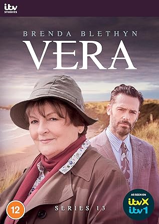 DVD cover for the series Vera featuring two main characters, a woman in a hat and a man in a suit, set against a coastal background.