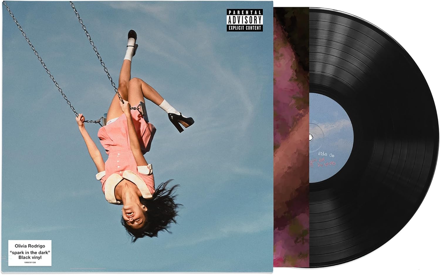 Vinyl record with a cover featuring a person on a swing against a blue sky, and a close-up of the record.