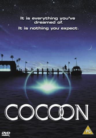 DVD cover for the movie 'Cocoon' featuring a nighttime scene with a group of people on a dock, with a large circular light in the foreground.