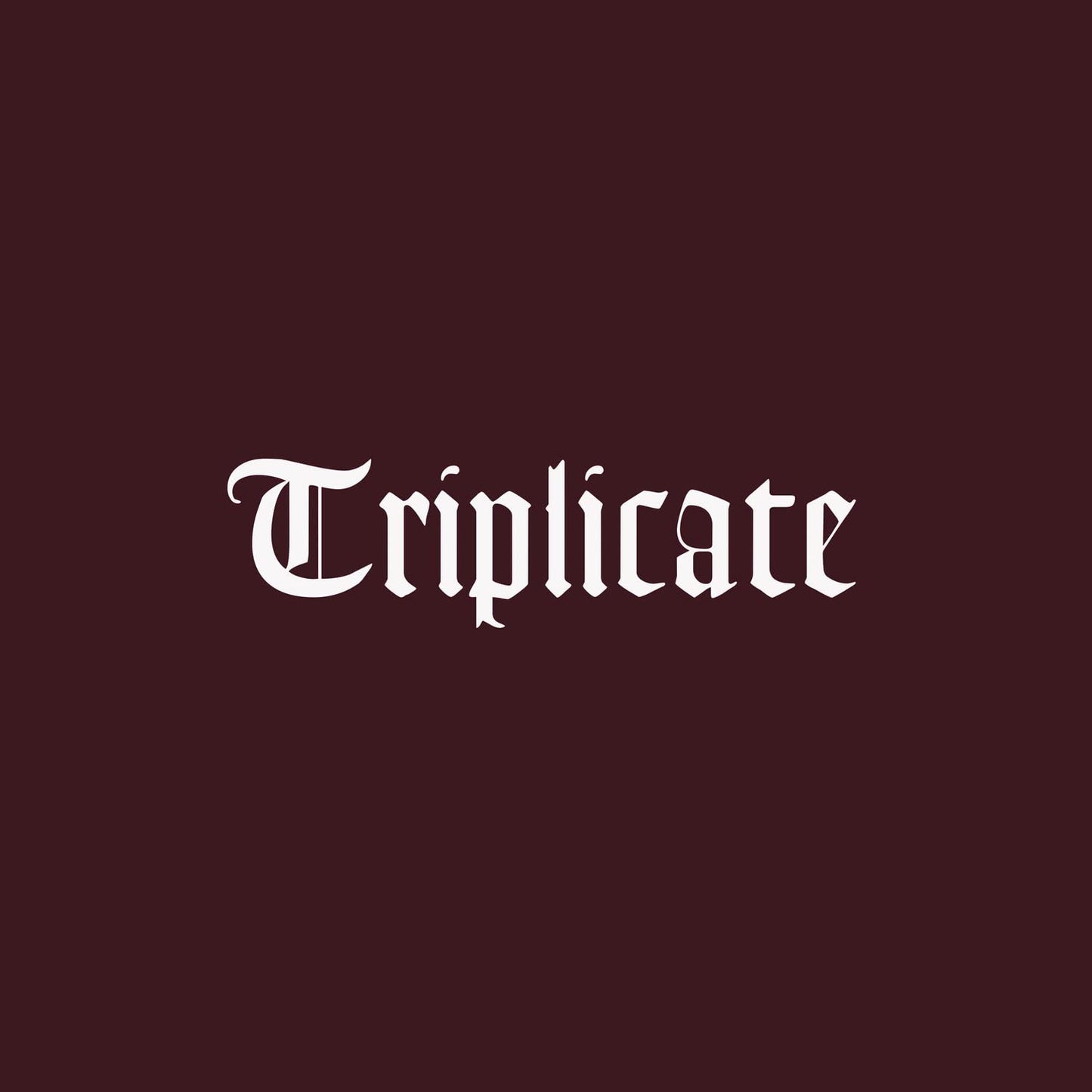 A vinyl record titled 'TRIPLICATE' by Bob Dylan in a box set format, with a maroon-colored sleeve.