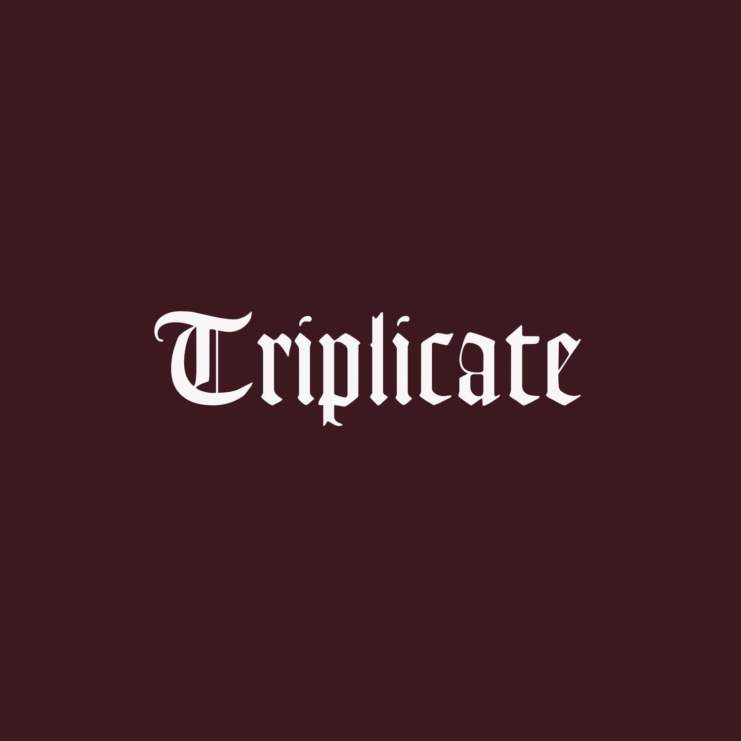 A vinyl record titled 'TRIPLICATE' by Bob Dylan in a box set format, with a maroon-colored sleeve.
